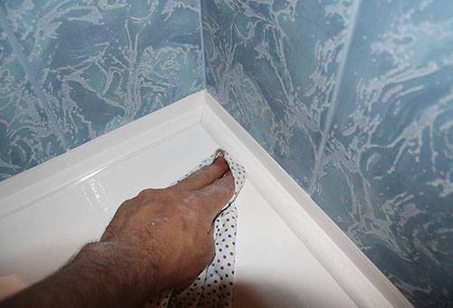 Removing excess silicone sealant from the bathtub