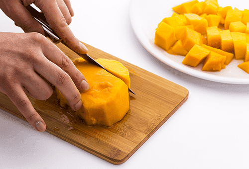 Cutting mango into salad cubes