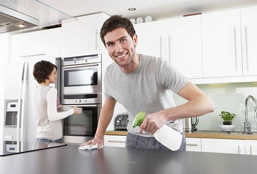 Par gør rengøringen i køkkenet