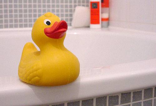 Rubber duckling on the side of the bath