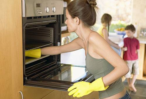 The girl washes the oven
