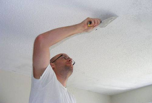 Removing whitewash from the ceiling with a spatula