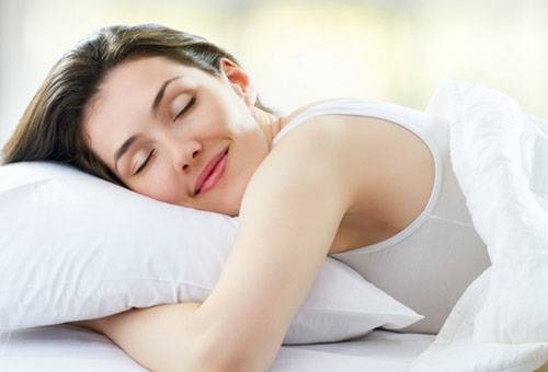Mujer durmiendo sobre una almohada limpia