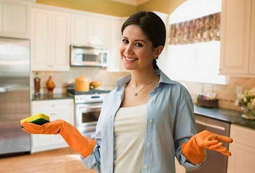 vrouw in de keuken met rubberen handschoenen