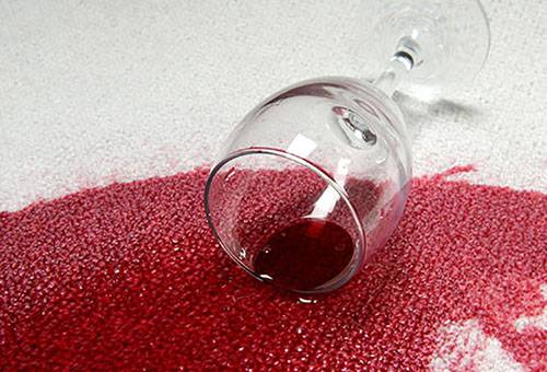 Izlijis vīns uz viegla paklāja