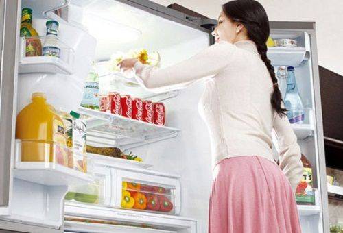 batang babae sa bukas na refrigerator