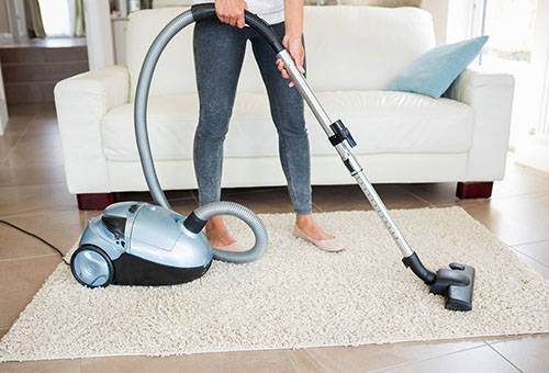 Babae vacuuming isang karpet
