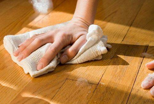 girl cleans the floor with a rag