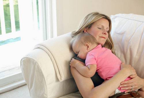 Femme avec un bébé sur le canapé