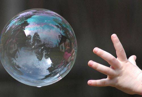 child's hand in a soap bubble