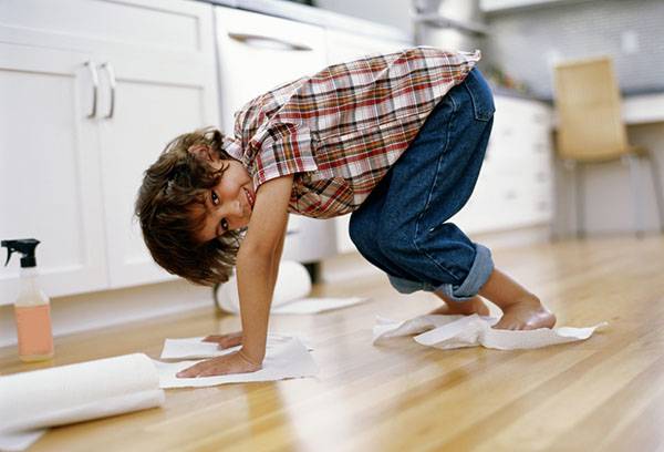 A gyermek csiszolja a padlót