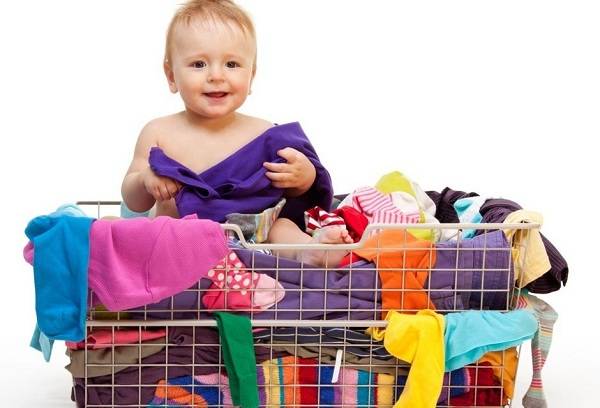 Bebé y ropa de bebé en una canasta