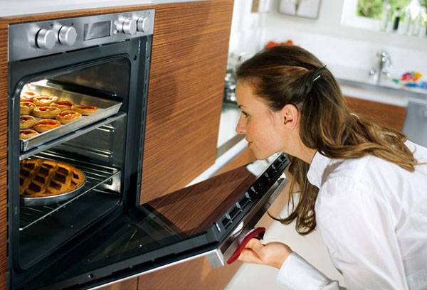 Woman cooks pastries in the oven