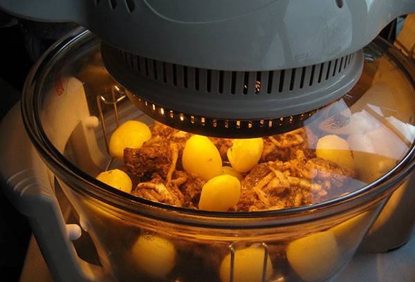 Cozinhar carne com batatas em uma grelha de ar