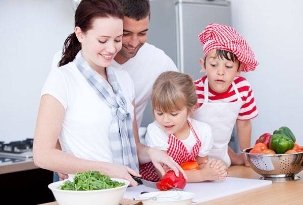 Familie in de keuken die een salade voorbereidt