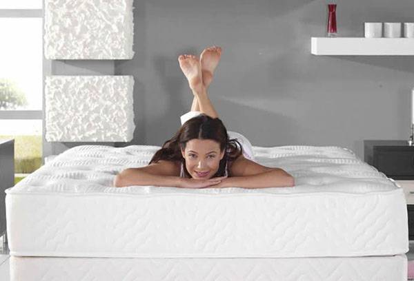 The girl lies on a new mattress