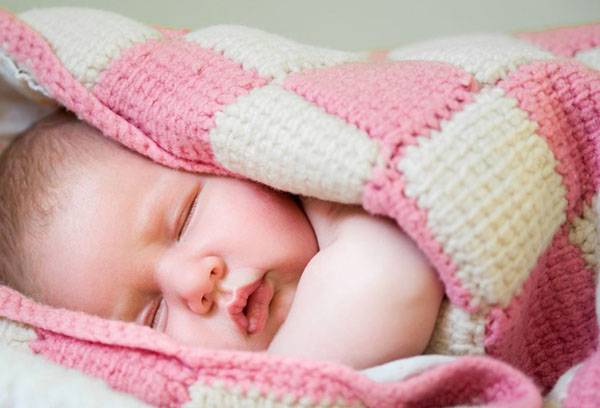 Newborn in a knitted blanket