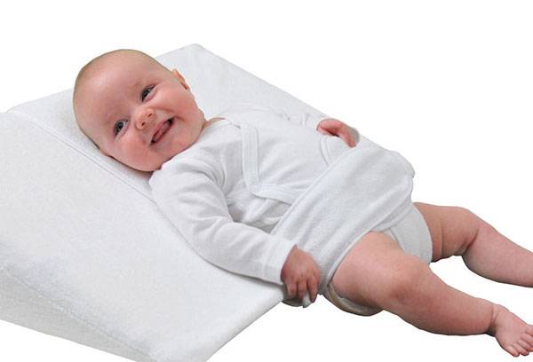 Bebê em um travesseiro inclinado