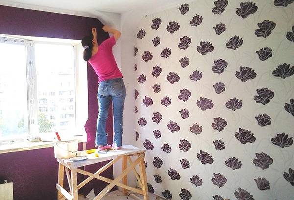Woman glues wallpaper