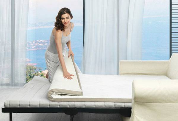 Woman folds mattress topper