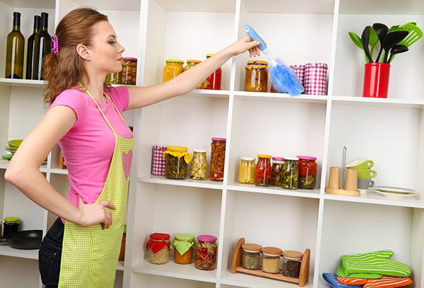 Girl tidies up shelves with groceries