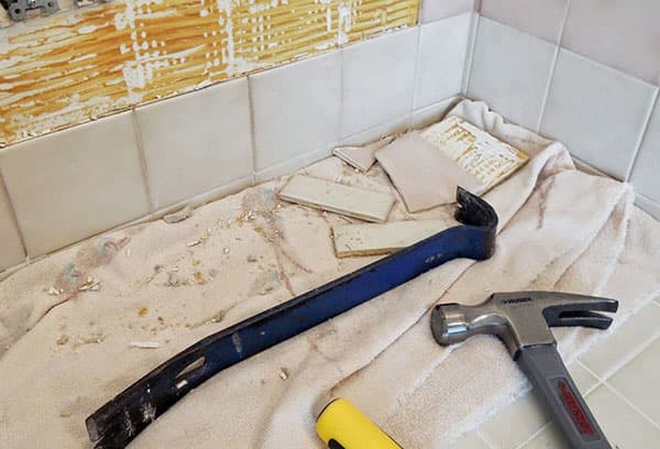 The process of dismantling old tiles in the bathroom