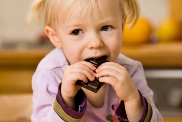 Maža mergaitė valgo hematogeną