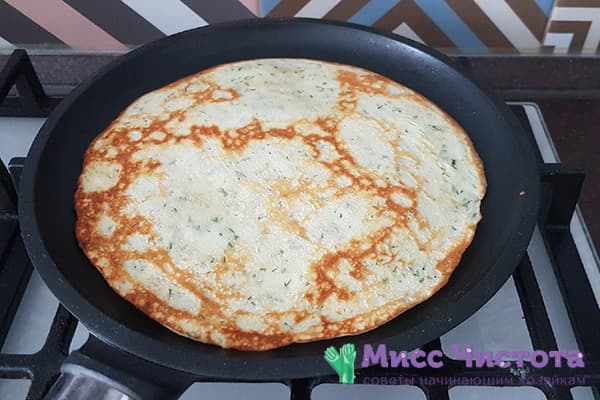 Pancake with cheese and herbs in a pan