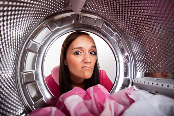 The girl looks in the washing machine