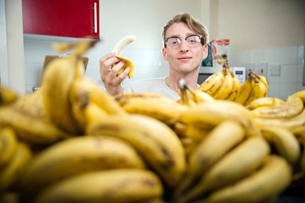 Hombre joven con plátanos