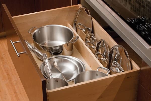 Storage compartment for lids in the pan drawer