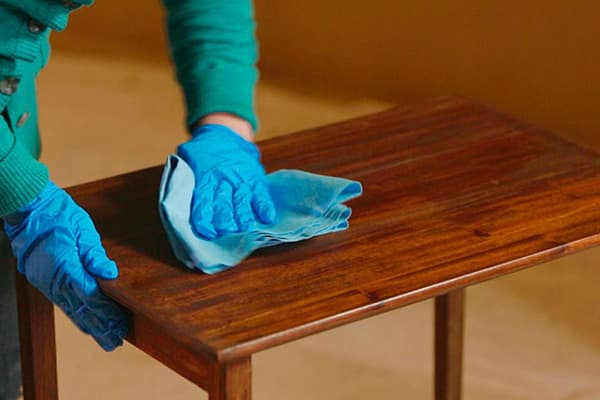 Processing a wooden table with furniture wax