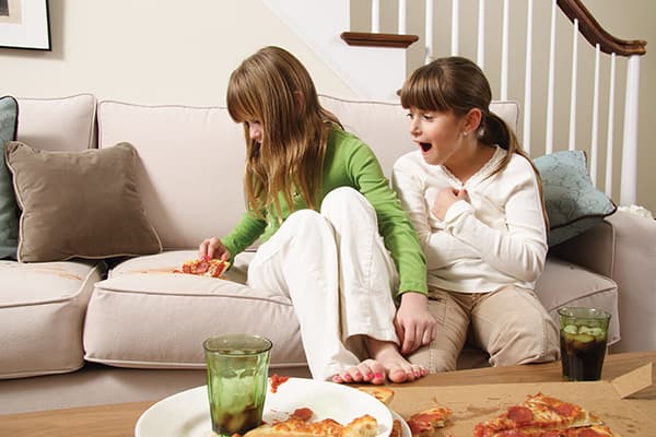 Cô gái đánh rơi một miếng pizza trên ghế sofa
