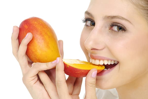 Dievča jesť mango