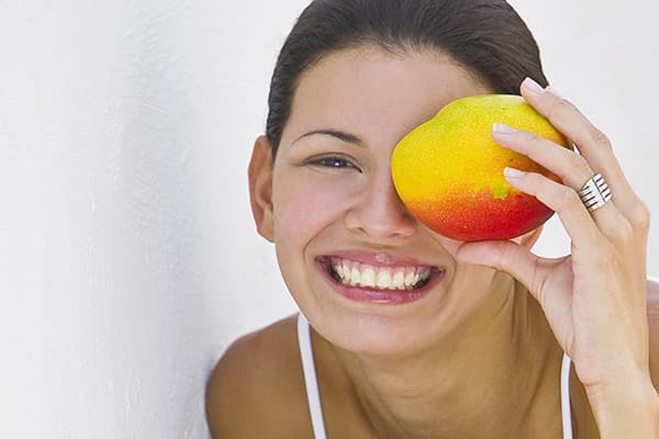 Mergaitė su mango vaisiais