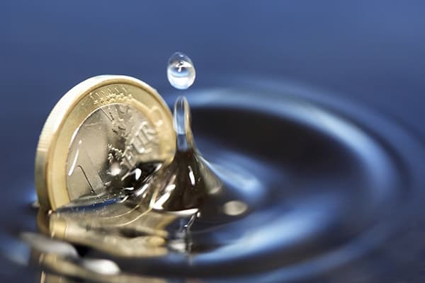 Mynt som faller ned i vann