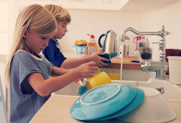 Los niños lavan los platos