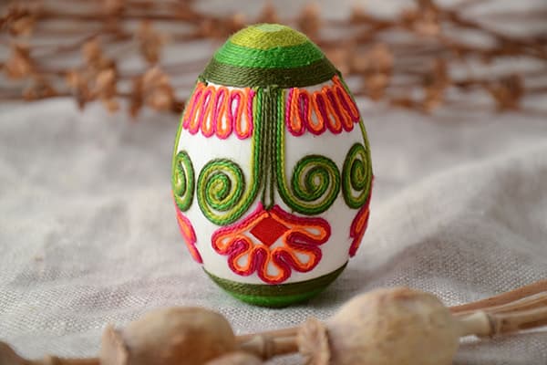 Huevo de Pascua decorado con hilos de colores.