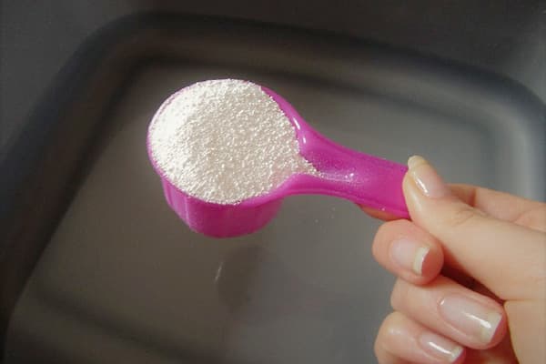 Jabón en polvo en una cuchara dosificadora