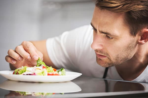 En mann undersøker en salat