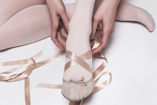 Girl puts on dancing ballet shoes