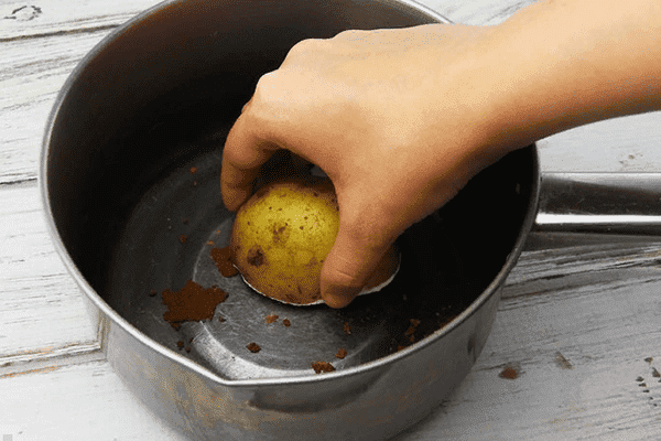 Cleaning pots with raw potatoes from rust