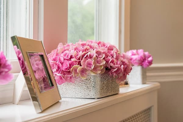 Eske med kunstige blomster i vinduskarmen