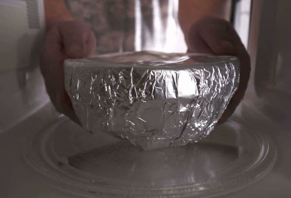 Mettre la vaisselle dans le papier d'aluminium au micro-ondes