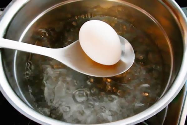 Dipping eggs in boiling water
