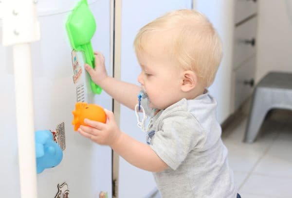 Játszó gyerek a hűtőszekrénynél