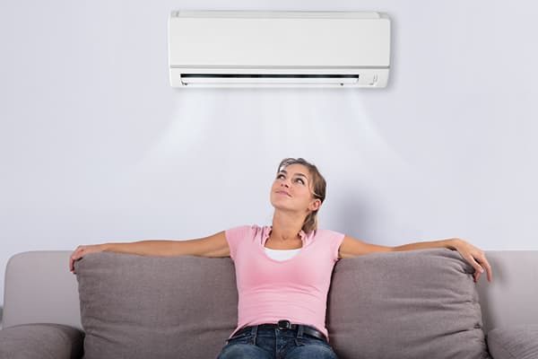 Girl sitting under air conditioning