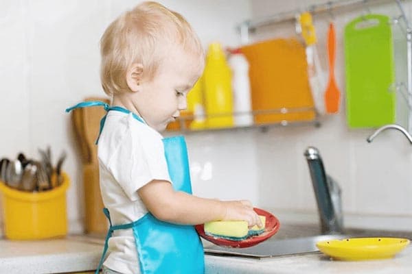 Il bambino lava i piatti