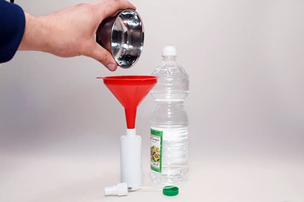 Despejando vinagre em uma garrafa de plástico
