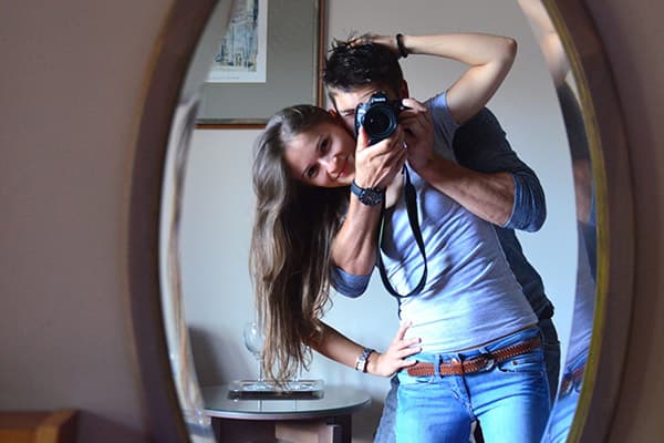 Jeune couple prenant des photos devant un miroir